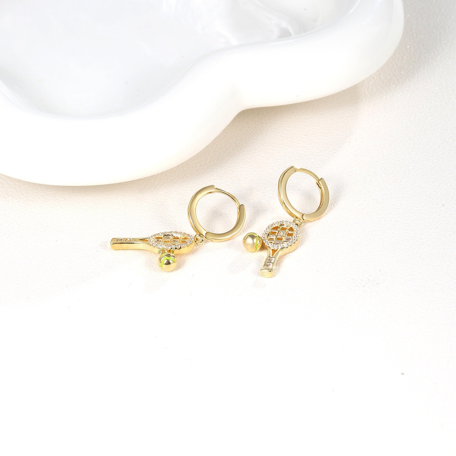 Aura flow tennis racquet earrings ear hoops – tennis jewelry in {{ product_color }} | Aura Tide Collective | Shop Aura flow tennis racquet earrings ear hoops online for {{ product_tags | join: ", " }} – Fast shipping worldwide.